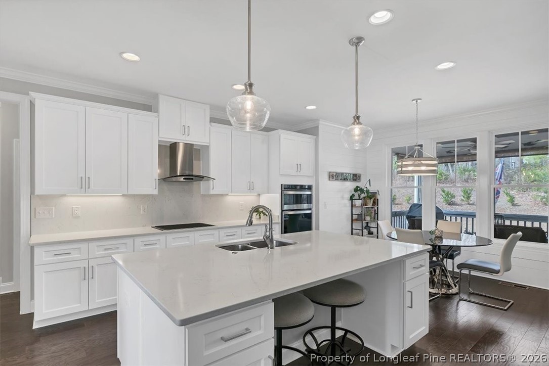 10 Heatherspring Way Spring Lake, NC 28390 - Photo 16 of 48 a kitchen with stainless steel appliances a table chairs refrigerator and cabinets