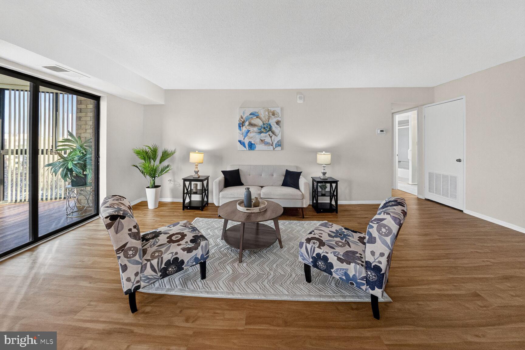 15107 Interlachen Drive, Unit 21025 Silver Spring, MD 20906 - Photo 5 of 38 a living room with furniture floor to ceiling window and wooden floor