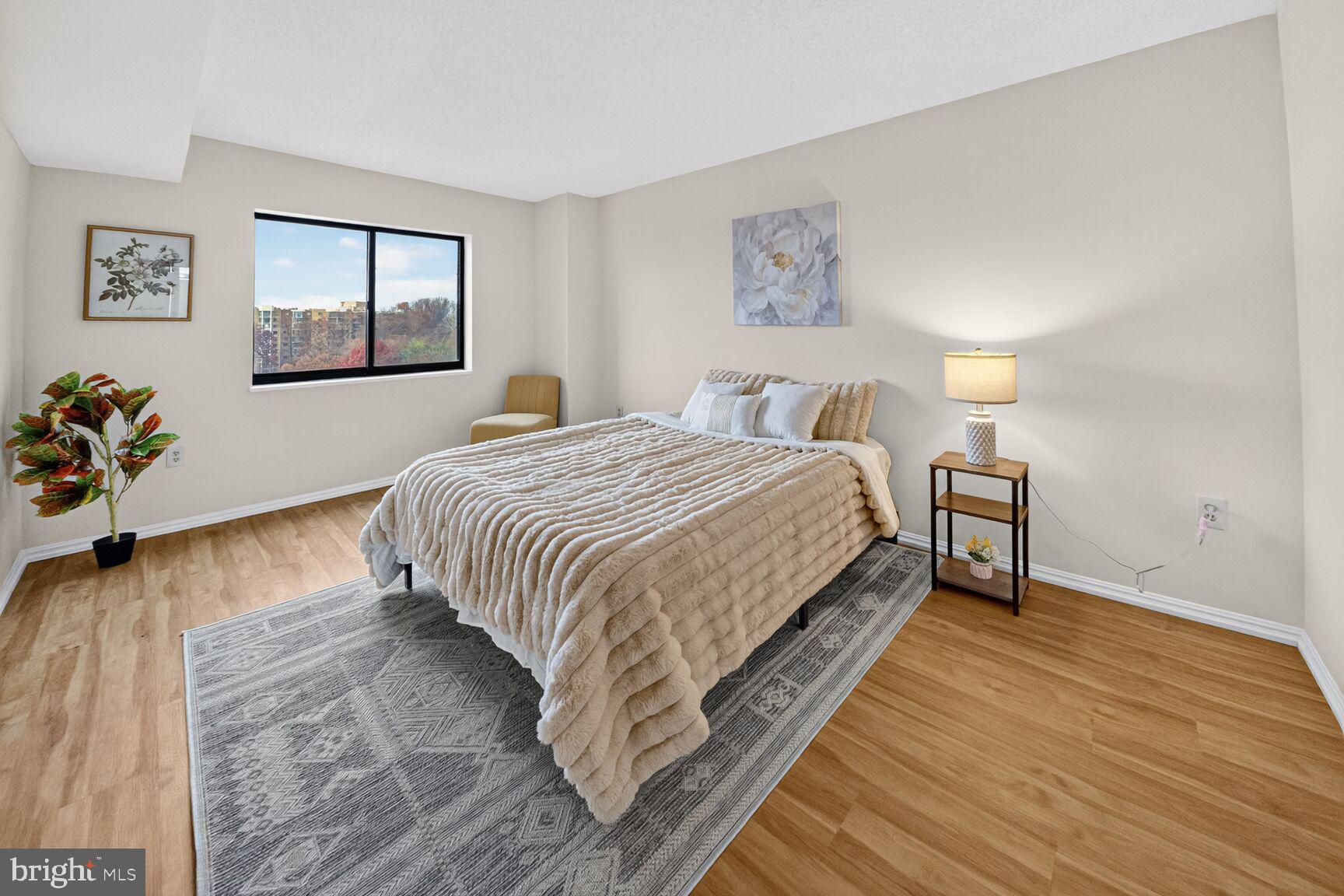 15107 Interlachen Drive, Unit 21025 Silver Spring, MD 20906 - Photo 8 of 38 a bedroom with a bed and a chandelier