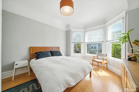 a bedroom with a bed and a large window