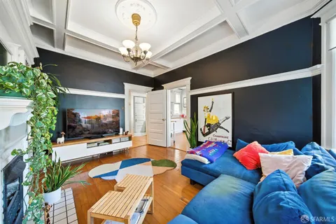 a kitchen with a refrigerator a sink dishwasher and white cabinets with wooden floor