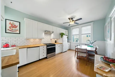 a kitchen with granite countertop a sink stove and refrigerator
