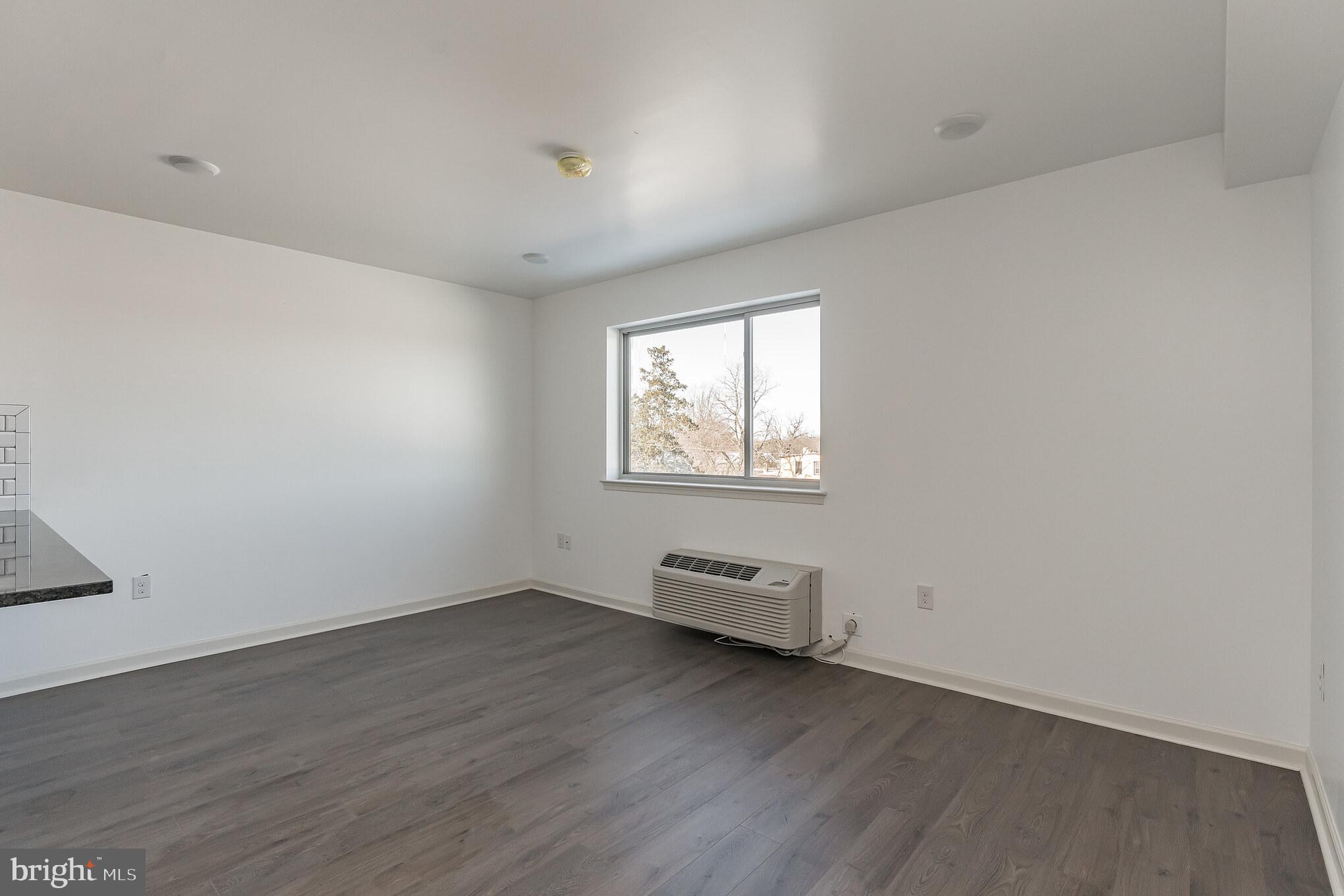 6649 Ridge Avenue, Unit A407 Philadelphia, PA 19128 - Photo 5 of 7 an empty room with wooden floor and windows