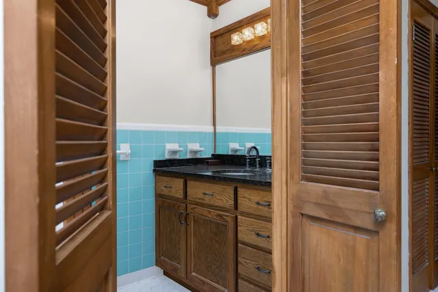 a bathroom with a granite countertop sink a toilet and shower