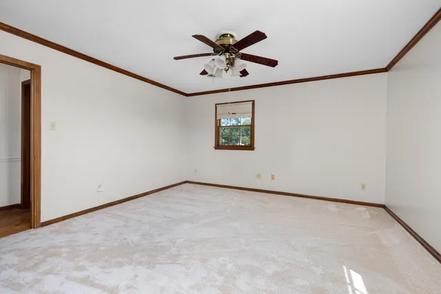 a view of a livingroom with a ceiling fan and window