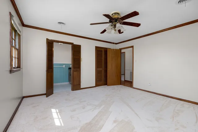 an empty room with windows and closet