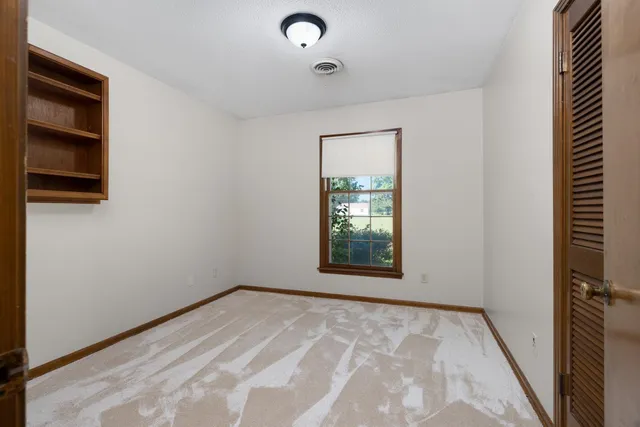 a view of an empty room with a kitchen