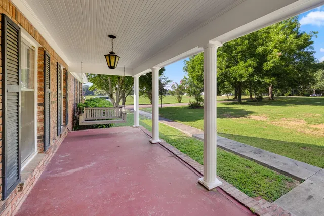 a view of a porch with furniture and garden