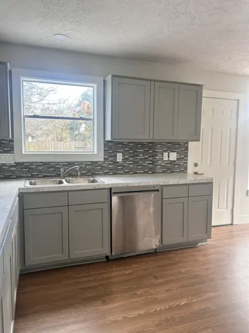 a kitchen with granite countertop white cabinets and a sink