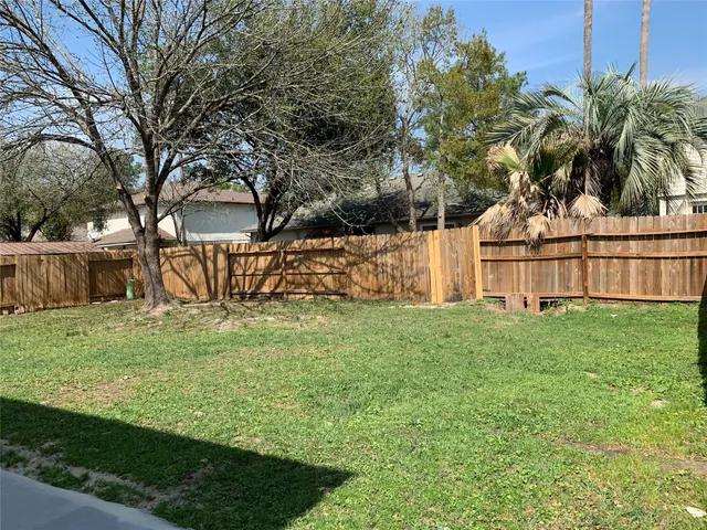 a view of a backyard with wooden fence