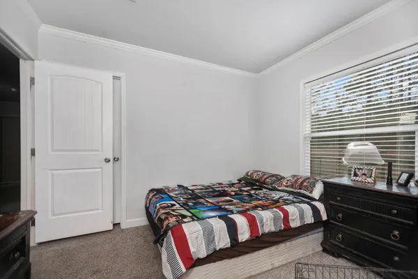 a bed sitting in a bedroom next to a window