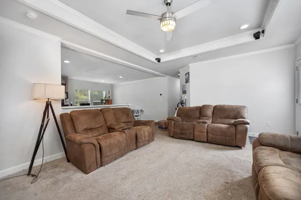 a view of a dining room with furniture a rug and kitchen view