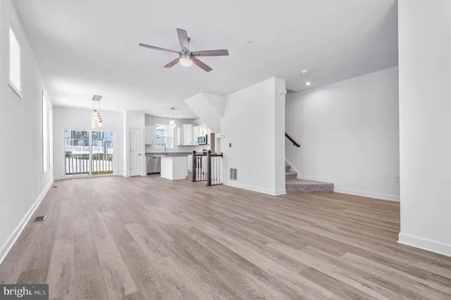 a kitchen with white cabinets and wooden floor