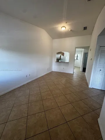 a view of a livingroom with wooden floor and a hallway
