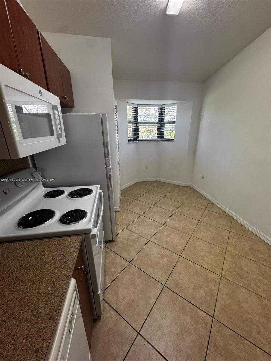 22621 Southwest 88th Place, Unit 3028 Cutler Bay, FL 33190 - Photo 10 of 18 a kitchen that has a sink and a stove