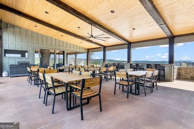 a dining room with furniture and a floor to ceiling window