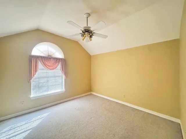 an empty room with windows and chandelier fan
