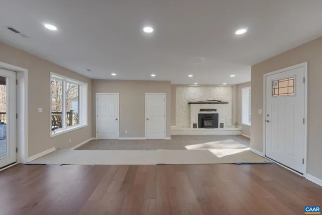 a view of an empty room with window and fire place