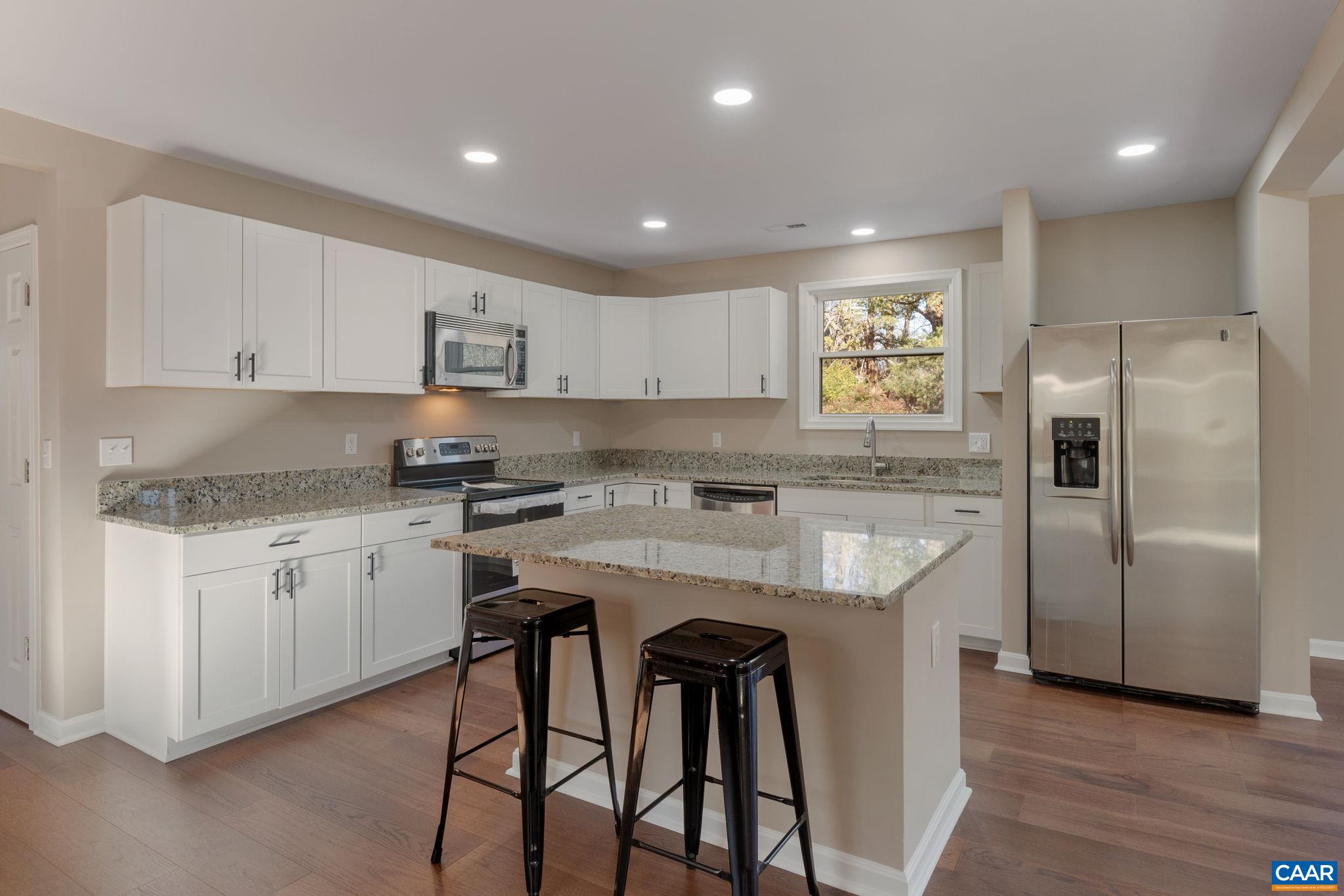 18503 Monrovia Road Orange, VA 22960 - Photo 17 of 39 a kitchen with kitchen island granite countertop a sink a center island and stainless steel appliances