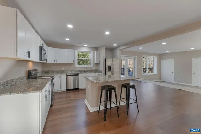 a kitchen with granite countertop white cabinets and white appliances