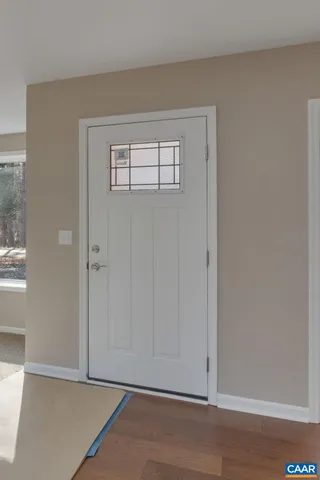 an empty room with windows and fireplace