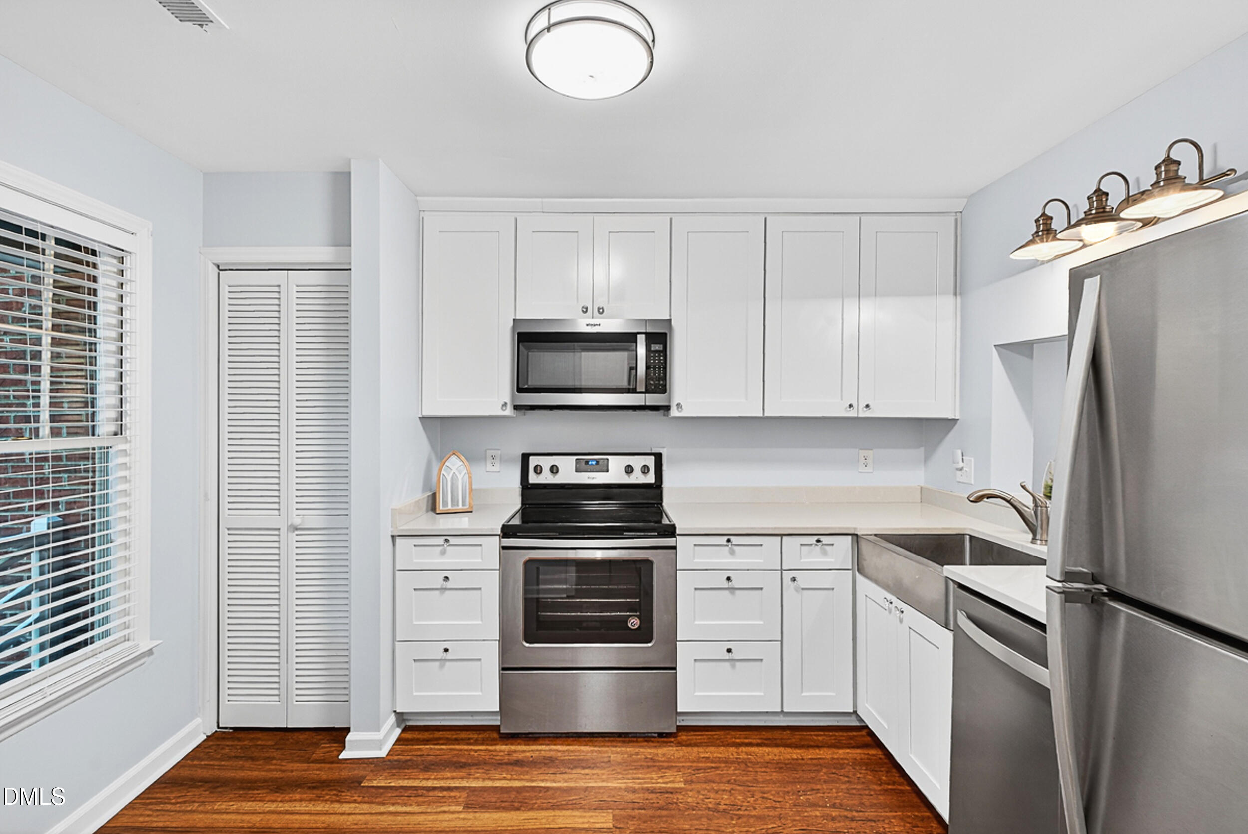 4617 Fawnbrook Circle Raleigh, NC 27612 - Photo 6 of 22 a kitchen with white cabinets and stainless steel appliances