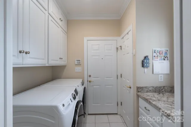 a utility room with cabinets washer and dryer