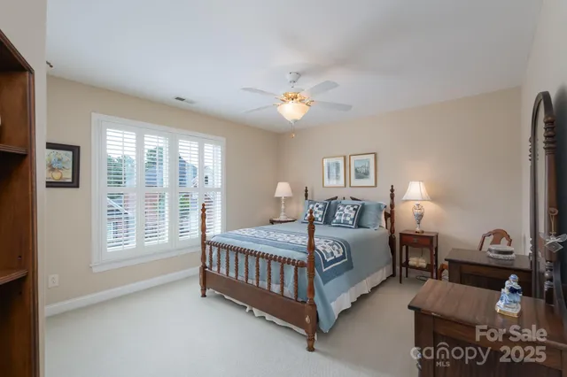 a spacious bedroom with a bed a chandelier and a window