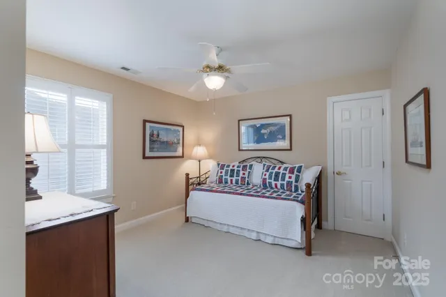 a white bed sitting in a bedroom next to a window
