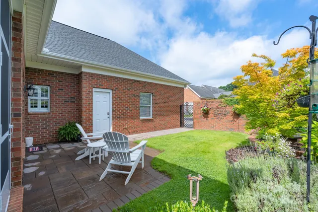 a patio with table and chairs and potted plants
