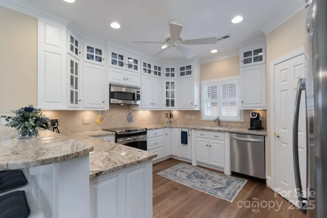 a kitchen with a sink stainless steel appliances and white cabinets