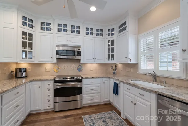 a kitchen with stainless steel appliances granite countertop a stove a sink and a microwave