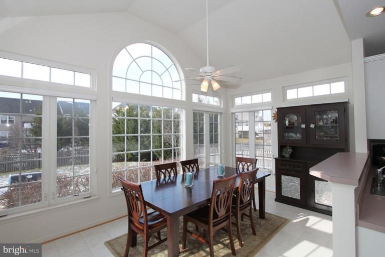 14208 Autumn Gold Road Boyds, MD 20841 - Photo 6 of 21 a view of a dining room with furniture large windows and a chandelier