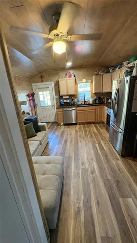 a view of a living room and kitchen with furniture wooden floor