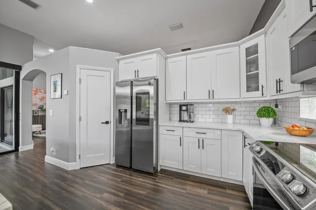 a kitchen with stainless steel appliances granite countertop a refrigerator a stove microwave and sink