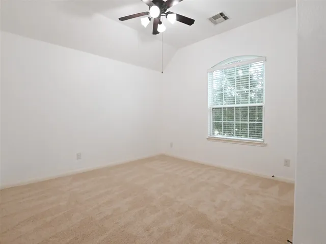 an empty room with a window and a fan