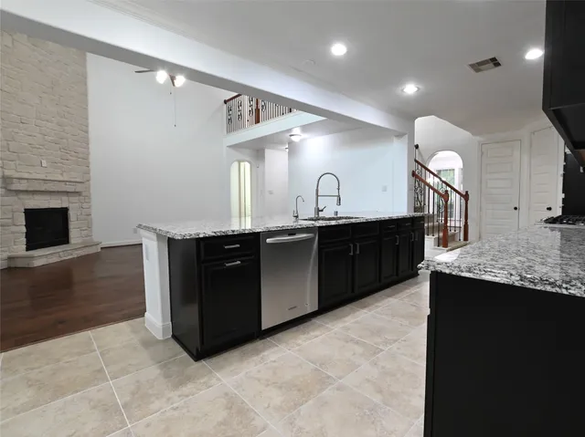 a kitchen with a sink and a stove top oven with wooden floor