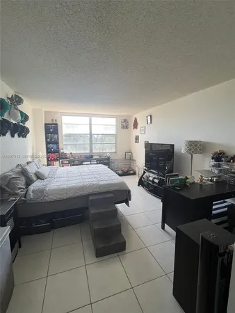 a living room with furniture a flat screen tv and a stove