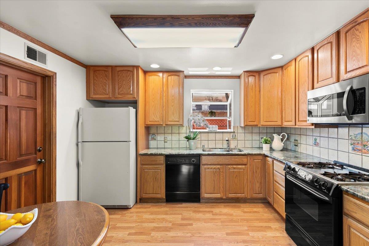 472 Helen Drive Millbrae, CA 94030 - Photo 13 of 35 a kitchen with stainless steel appliances granite countertop a stove a sink dishwasher a refrigerator and a dining table with wooden floor