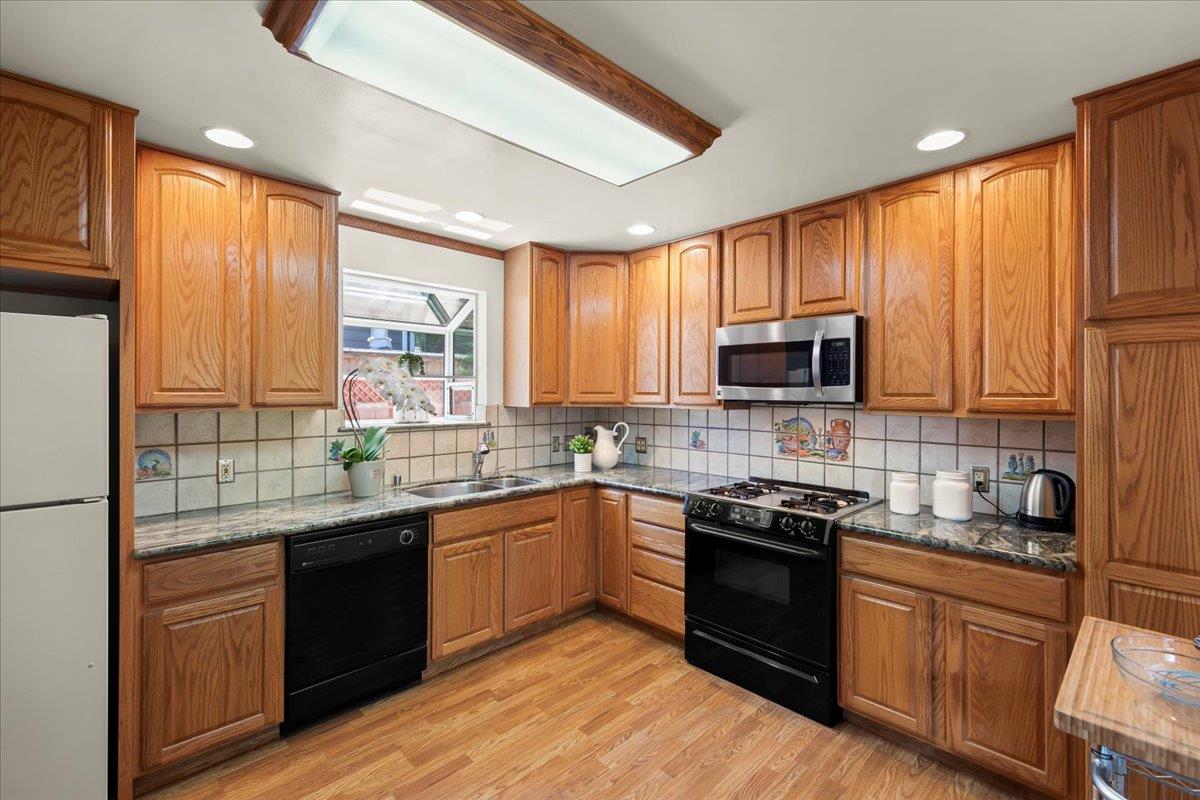 472 Helen Drive Millbrae, CA 94030 - Photo 14 of 35 a kitchen with stainless steel appliances granite countertop wooden cabinets a sink a stove a refrigerator with grey cabinets and wooden floor