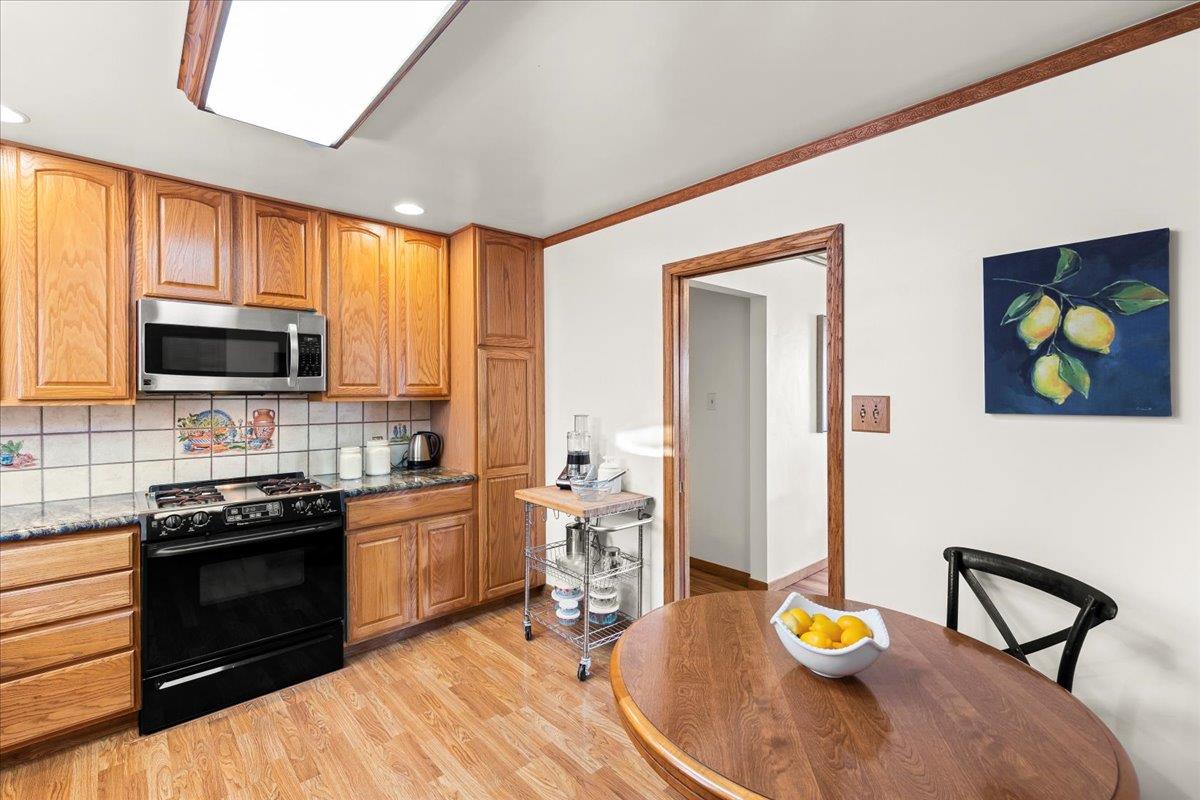 472 Helen Drive Millbrae, CA 94030 - Photo 15 of 35 a kitchen with stainless steel appliances wooden floor dining table and chair