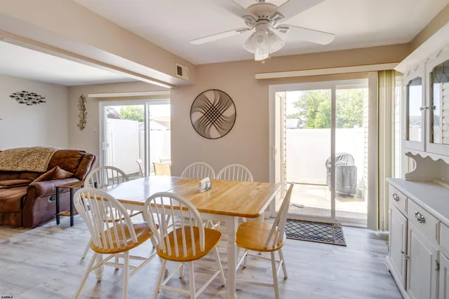 a dining room with furniture a chandelier and wooden floor