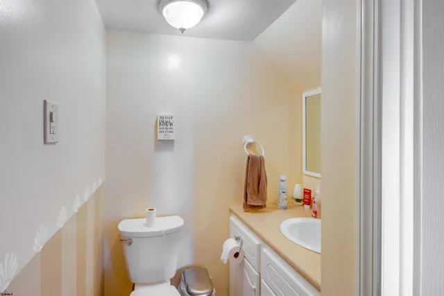 a bathroom with a sink vanity mirror and toilet