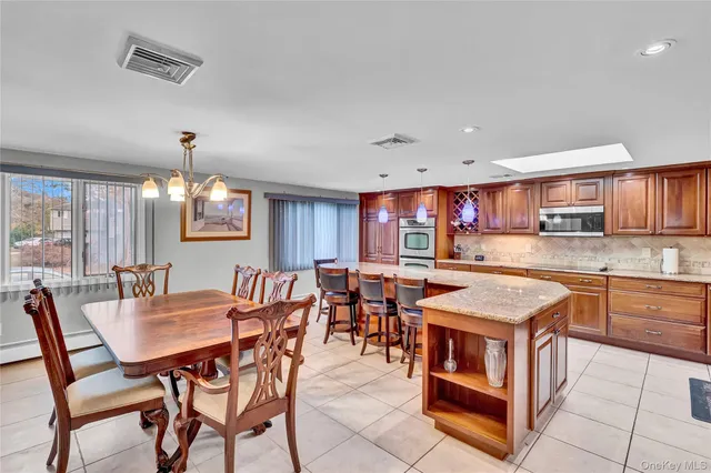 a dining hall with stainless steel appliances granite countertop a dining table and chairs