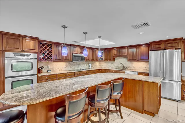 a kitchen with stainless steel appliances granite countertop a sink and a refrigerator