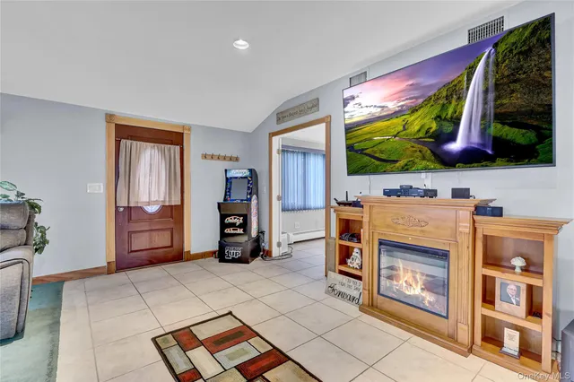 a living room with furniture a flat screen tv and a floor to ceiling window