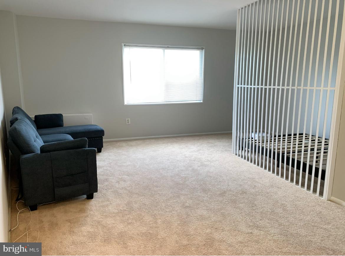 1111 University Boulevard West, Unit 501A Silver Spring, MD 20902 - Photo 5 of 13 a living room with furniture and a window