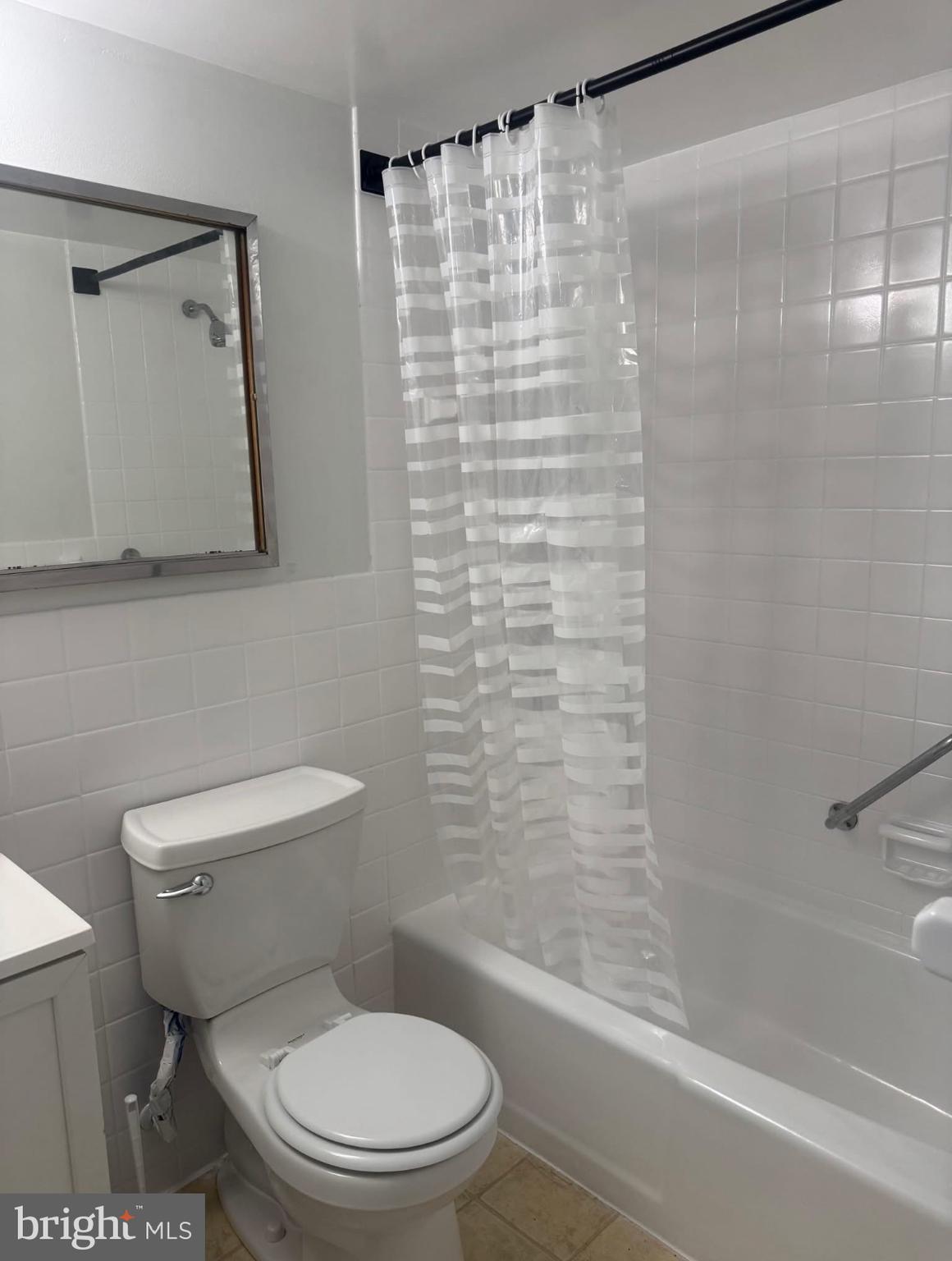 1111 University Boulevard West, Unit 501A Silver Spring, MD 20902 - Photo 10 of 13 a white toilet sitting next to a bath tub and a shower