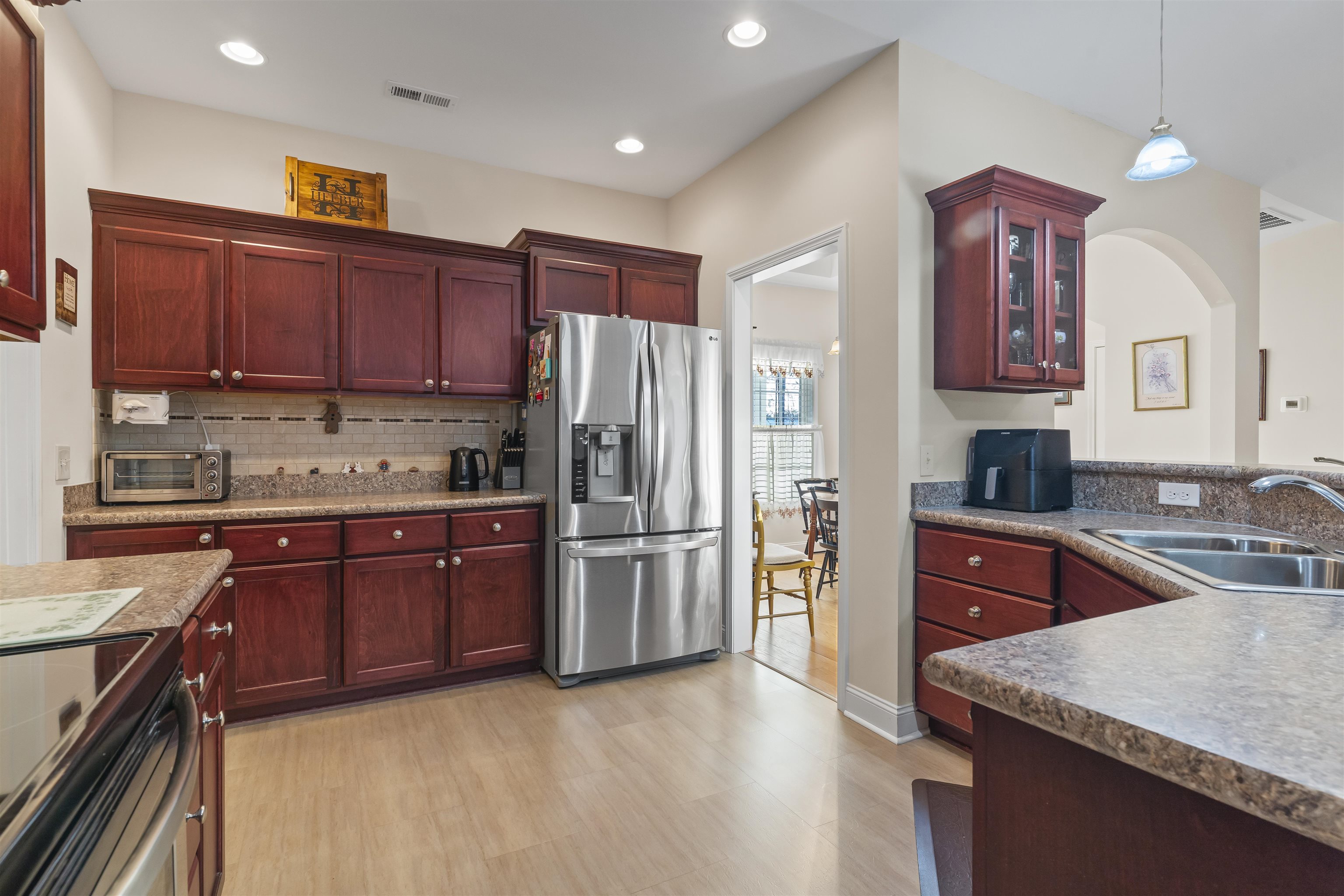 830 Payne Court Conway, SC 29526 - Photo 11 of 38 Kitchen with reddish brown cabinets, stainless steel appliances, glass insert cabinets, decorative light fixtures, and recessed lighting