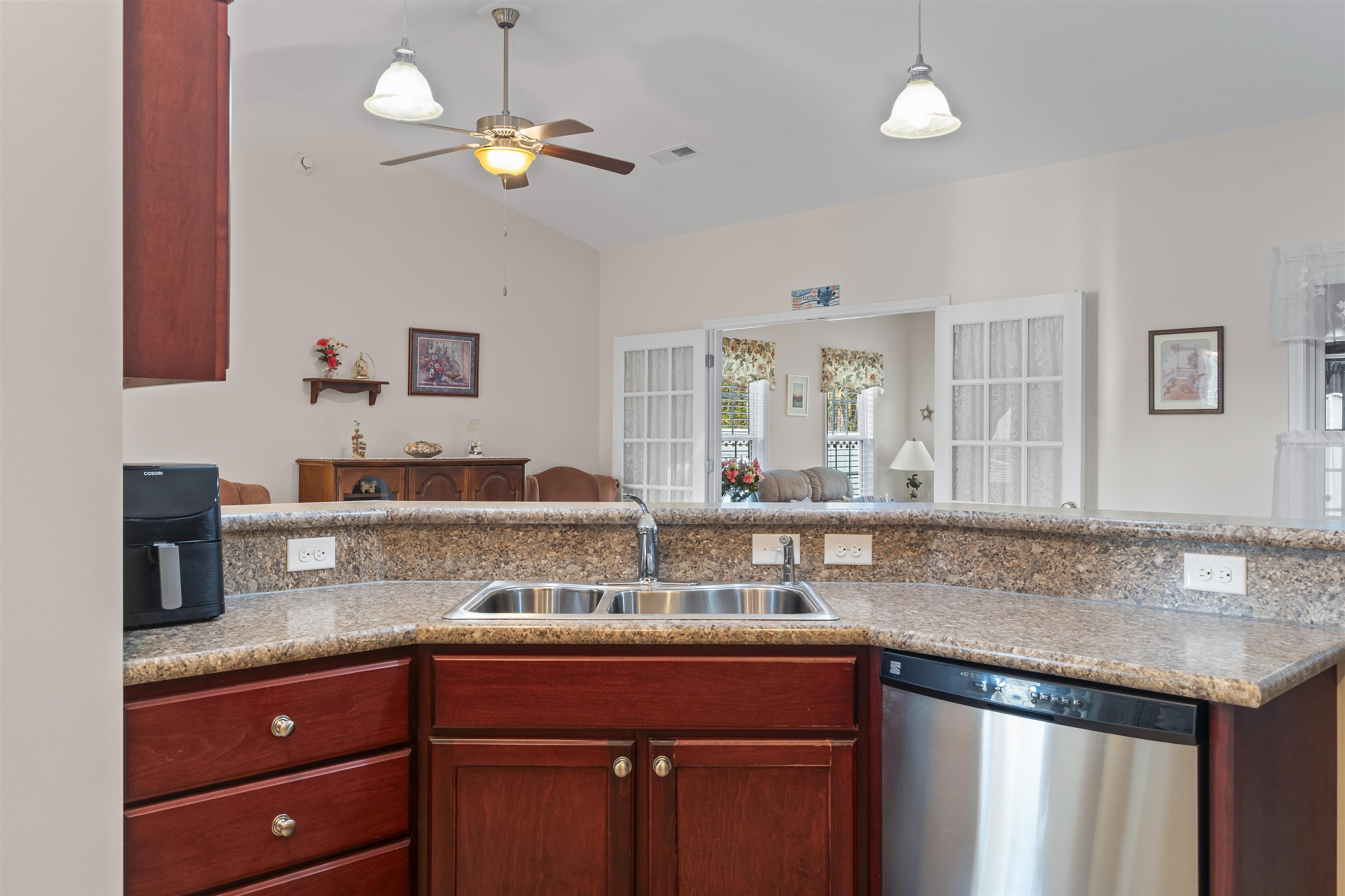 830 Payne Court Conway, SC 29526 - Photo 38 of 38 Kitchen featuring open floor plan, dishwasher, hanging light fixtures, vaulted ceiling, and reddish brown cabinets